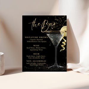 May include: A black bar menu sign with gold lettering and a martini glass. The sign lists signature drinks, wine, beer, and non-alcoholic beverages. A lemon slice and peel garnish the martini.