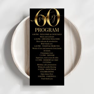 May include: A black and gold 60th birthday program card. The card features the word "PROGRAM" in gold lettering, along with a detailed schedule of events. The card is set against a white background.