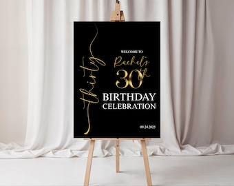 Può includere: Cartello nero su cavalletto con testo dorato. Il cartello recita "Benvenuti al 30° compleanno di Rachel" con la data 09.24.2025. Il cartello è esposto davanti a una tenda bianca.