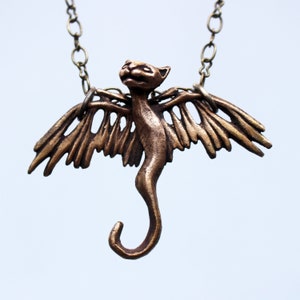 Cat necklace flying winged creature sculpture