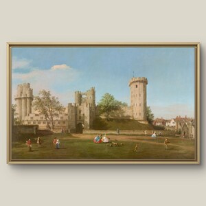 May include: A framed painting depicting a castle with several towers and a green lawn. People are seen on the lawn. The sky is blue with clouds. The painting is in a gold frame.