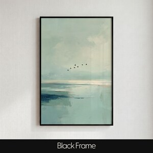 May include: A framed wall art print featuring an abstract landscape in shades of pale blue, teal, and white. The composition depicts a calm body of water meeting a soft sky, with a small flock of black birds flying across the center horizon.