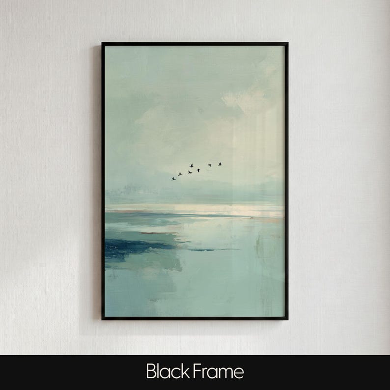 May include: A framed wall art print featuring an abstract landscape in shades of pale blue, teal, and white. The composition depicts a calm body of water meeting a soft sky, with a small flock of black birds flying across the center horizon.