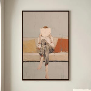 May include: An abstract painting shows a person reading a book while seated on a sofa. The person wears a white shirt and striped trousers. The sofa has yellow and orange cushions. The artwork is framed in a dark brown frame.
