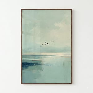 May include: A vertical rectangular wall art print featuring an abstract landscape with soft, muted shades of pale blue, teal, and white. A small flock of black birds is depicted in flight across the center of the composition above the water.