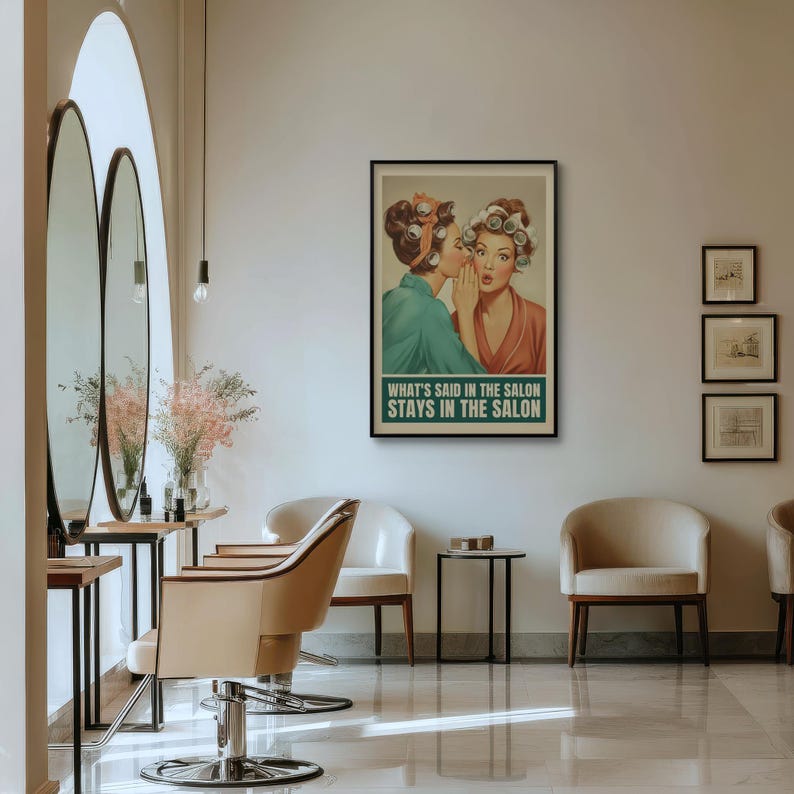 May include: A framed vintage-style poster with the text "WHAT'S SAID IN THE SALON STAYS IN THE SALON" hangs on a wall. The poster depicts two women in curlers, one whispering to the other. The salon interior features mirrors, chairs, and a table.
