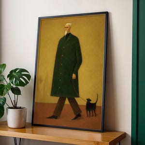 May include: Framed art print featuring a man in a long green coat walking a black cat on a leash. The artwork has a minimalist style with a yellow background and a black frame. The man has white hair and a beard.