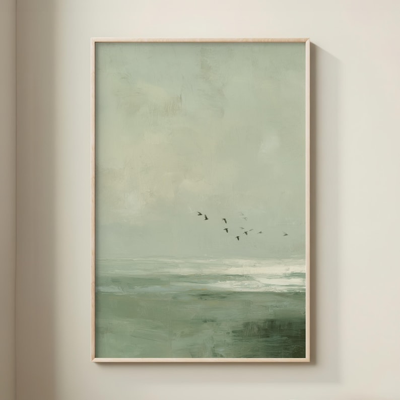 May include: A framed abstract landscape painting in shades of green and white. The artwork depicts a seascape with a flock of birds in flight against a muted sky. The painting has a textured, brushstroke appearance, creating a serene and natural aesthetic.