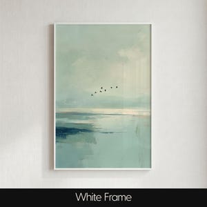 May include: A vertical wall art print featuring a serene landscape with soft, muted shades of pale blue, teal, and white. The composition depicts a calm body of water meeting a hazy horizon, with a small flock of black birds flying across the sky.