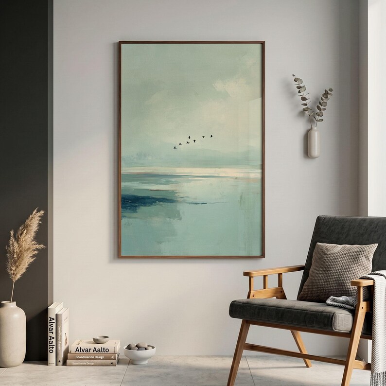 May include: A vertical rectangular wall art print featuring an abstract landscape in shades of sage green, pale blue, and dark navy. The composition depicts a calm horizon line with a small flock of black birds flying across the cloudy sky.