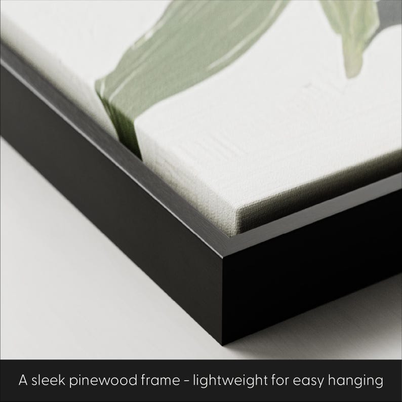 May include: Close-up of a black pinewood frame. The frame surrounds a canvas with a green and white abstract design. The text at the bottom reads: "A sleek pinewood frame - lightweight for easy hanging."