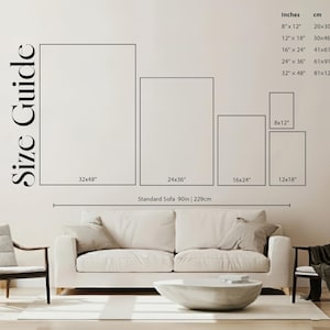 May include: A wall art size guide displays various rectangular frame sizes in inches and centimeters. The sizes range from 8x12 inches (20x30cm) to 32x48 inches (81x122cm). The text "Size Guide" is on the left. A sofa is below the guide.