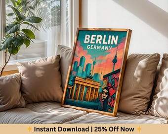Puede incluir: Un cuadro enmarcado con una colorida ilustración de Berlín, Alemania. La obra de arte muestra la Puerta de Brandeburgo, el horizonte de la ciudad y el texto "BERLIN GERMANY". La impresión tiene un marco de madera y se muestra en un sofá.