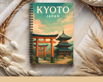 May include: Spiral-bound notebook featuring a scenic illustration of Kyoto, Japan, with the text "KYOTO JAPAN" in white. The cover art depicts traditional Japanese architecture and a landscape with orange torii gates. The notebook measures 6" x 8".