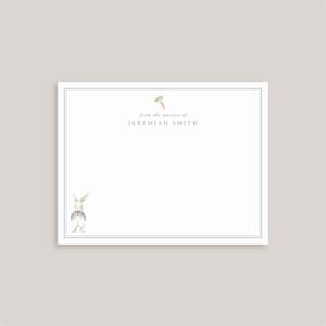 May include: A white rectangular stationery card with a thin blue double-line border. The card features a small watercolor illustration of a carrot at the top center, a rabbit in blue overalls at the bottom left, and the text from the nursery of JEREMIAH SMITH.