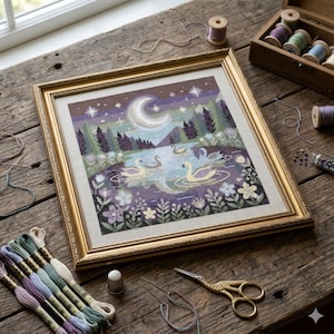 May include: Framed cross-stitch art featuring a serene lake scene with swans, a crescent moon, and stars. The artwork is in a gold frame, surrounded by embroidery supplies like thread, scissors, and a thimble. The color palette includes purples, greens, and golds.