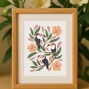 May include: A framed cross-stitch design featuring three toucans perched on a branch with pink flowers and green leaves.