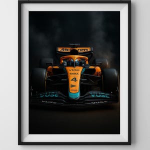 Puede incluir: Impresión enmarcada de un coche de carreras de Fórmula 1. El coche es naranja y azul con el número 4 en el lateral. El logotipo de McLaren es visible. El fondo es oscuro con un efecto ahumado.