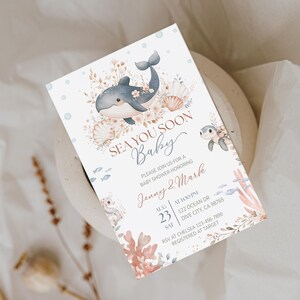 K&ouml;nnte beinhalten: Eine Babyparty-Einladung mit Aquarelldesign. Die Einladung zeigt einen Wal, Muscheln und Korallen. Der Text lautet "Sea You Soon Baby" und enth&auml;lt Details zur Veranstaltung, einschlie&szlig;lich Datum, Uhrzeit und Ort.