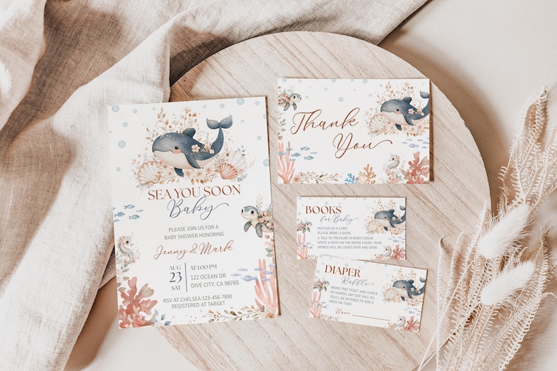 K&ouml;nnte beinhalten: Ein Babyparty-Einladungsset mit Meeresthema. Die Einladung und die dazugeh&ouml;rigen Karten zeigen Illustrationen von Walen, Muscheln und Korallen in sanften Blau-, Beige- und Korallt&ouml;nen. Auf der Einladung steht "Sea You Soon Baby".