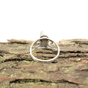 May include: A silver ring with an intricate design and the inscription "925" on the inside of the band.