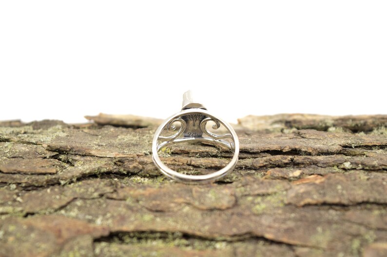 May include: A silver ring with an intricate design and the inscription "925" on the inside of the band.