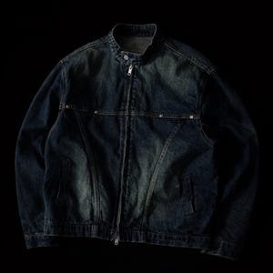 以下が含まれることがあります： スタンドカラーとフルレングスのジッパーが付いた、濃い色のデニムジャケット。 ジャケットは、ポケットとシルバーのトーンのリベットを備えたクラシックなデザインです。 黒い背景に表示されています。