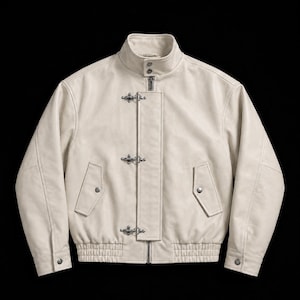 May include: An off-white leather jacket featuring a stand-up collar, a central zipper closure, and a vertical placket secured by three silver-toned metal hook-and-eye fasteners. The jacket includes two side pockets with snap buttons and ribbed cuffs.