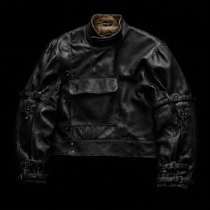 Puede incluir: Una chaqueta de cuero negro con cuello alto y cierre de broche, un bolsillo rectangular grande en el pecho con solapa y m&uacute;ltiples correas con hebilla ajustables en las mangas y los pu&ntilde;os. La chaqueta tiene un forro interior de color beige.