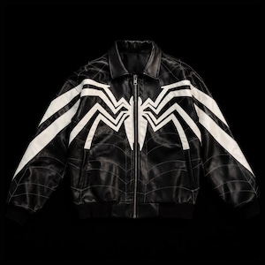 May include: A black jacket featuring a large white spider emblem across the chest and sleeves. The garment includes a full-length front zipper, a classic collar, and subtle thin white lines forming a web pattern across the entire black surface.