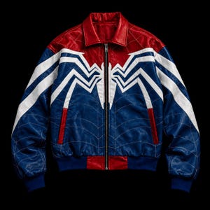 Op de afbeelding: Een leren bomberjack met een rood bovenstuk en een blauw onderstuk, voorzien van een groot wit spinnenembleem op de borst. De jas heeft een ritssluiting over de gehele lengte, een klassieke kraag en dunne, gestikte witte webpatronen.