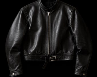 May include: A black leather jacket featuring a stand-up collar with a snap button closure, a full-length silver-tone metal front zipper, long sleeves with snap button cuffs, and an adjustable waist strap with a silver-tone metal buckle.
