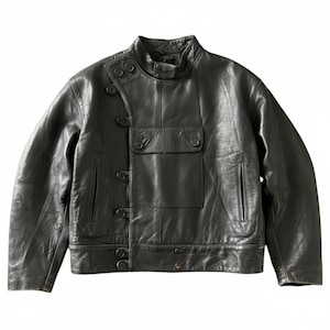 Puede incluir: Una chaqueta de cuero negro con cuello alto y cierre de broche, tapeta de botones frontal asimétrica y un bolsillo rectangular grande en el pecho con solapa. La chaqueta incluye dos bolsillos verticales con costuras triangulares reforzadas.