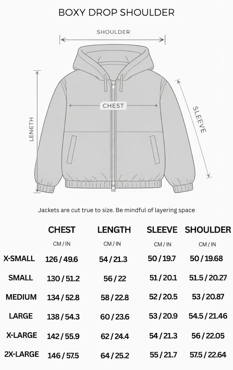 Op de afbeelding: Een lijntekening van een jack met capuchon, verlaagde schouders en een ritssluiting aan de voorzijde. Het diagram toont labels voor schouder-, borst-, lengte- en mouwmaten. Een tabel geeft de afmetingen in cm voor maten X-Small tot 2X-Large.