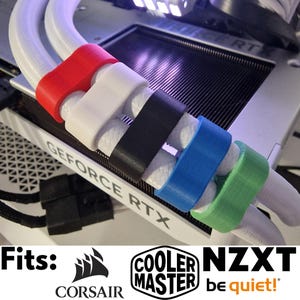 Puede incluir: Primer plano de un componente de computadora con cables blancos y organizadores de cables de colores rojo, blanco, negro, azul y verde. El texto "GEFORCE RTX" es visible. También se ven los logotipos de Corsair, Cooler Master y NZXT.