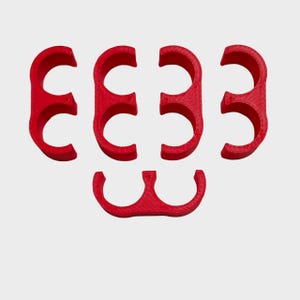 May include: Red, semi-circular objects arranged in a pattern. The objects have a smooth, matte finish and are evenly spaced against a white background. The shapes are reminiscent of the number three.