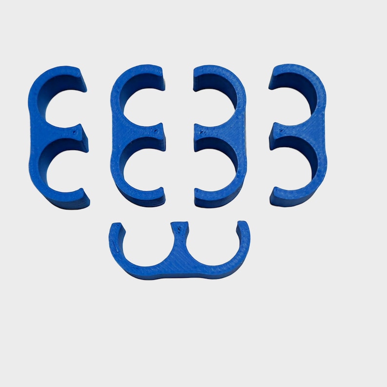 May include: A collection of six bright blue, semi-circular plastic clips. The clips are arranged in a pattern, with four in a row and two below. The objects are made of a solid, smooth material.