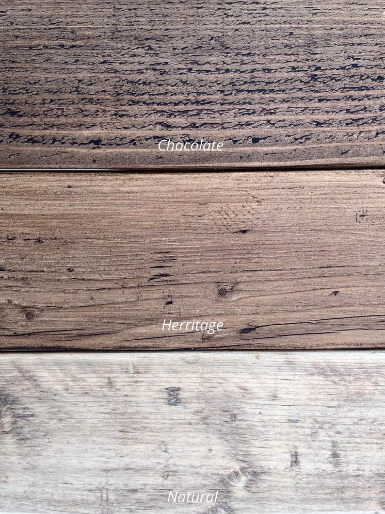 Op de afbeelding: Close-up van drie houten planken met verschillende afwerkingen. De bovenste plank is donker chocoladebruin, de middelste plank is bruin en de onderste plank is licht en natuurlijk van kleur. De tekst "Chocolate", "Herritage" en "Natural" is zichtbaar.