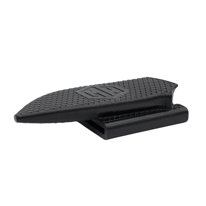 Puede incluir: Un tope de puerta negro en forma de cu&ntilde;a, con una superficie texturizada y las letras "HW" en relieve en la parte superior. El tope de puerta tiene una base rectangular y una parte superior inclinada, dise&ntilde;ada para evitar que las puertas se cierren.