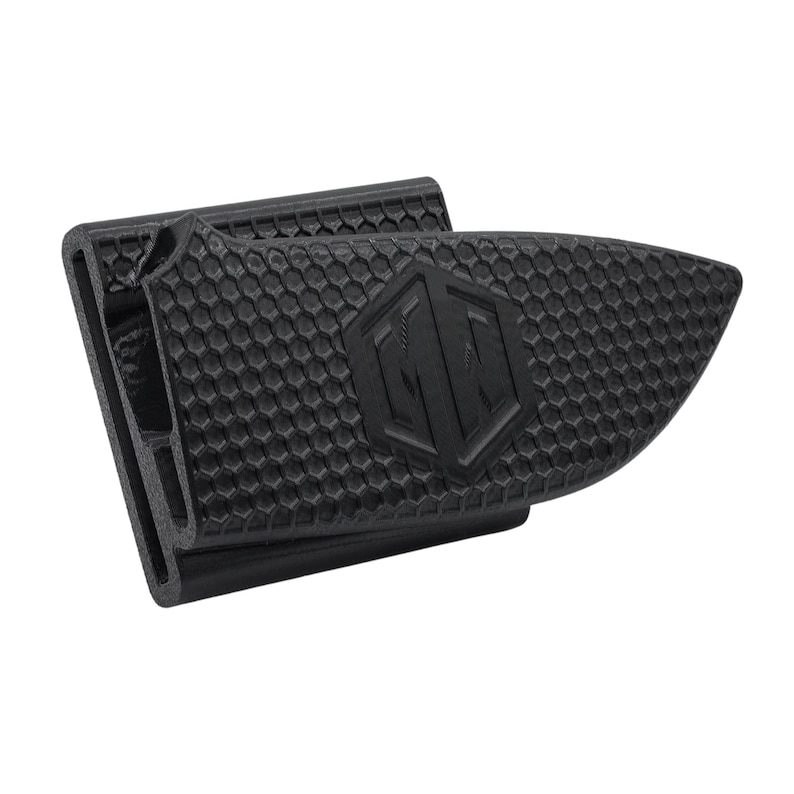 Puede incluir: Un clip para billetes negro con superficie texturizada y patr&oacute;n geom&eacute;trico. El clip presenta un emblema en relieve y un dise&ntilde;o hexagonal. Dise&ntilde;ado para sujetar billetes y tarjetas.