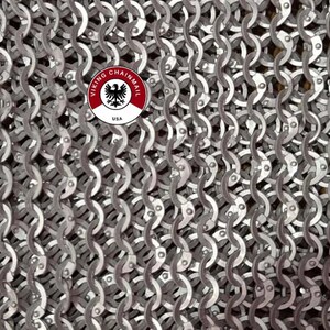 Puede incluir: Primer plano de una tela de cota de malla con un patr&oacute;n repetitivo de anillos met&aacute;licos entrelazados. El metal es de color plateado. Un logotipo circular con el texto "VIKING CHAINMAIL USA" es visible.