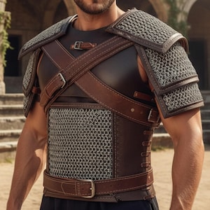 May include: A brown and black leather and chainmail armour set. The armour features shoulder pads, a chest piece, and straps with buckles. The chainmail is silver-coloured.
