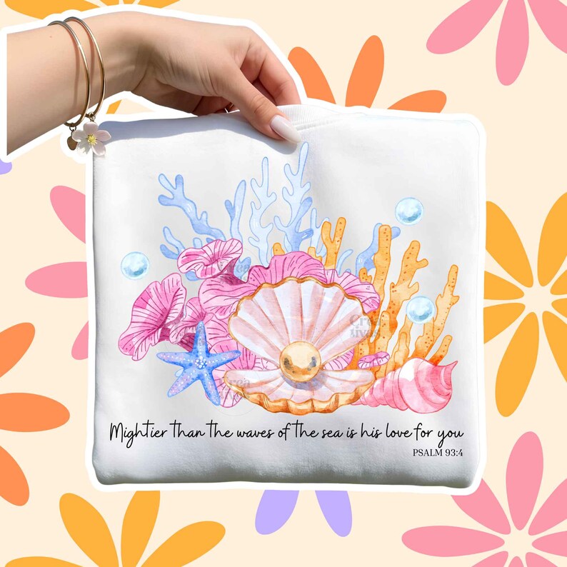 May include: A white sweatshirt featuring a watercolor illustration of a pearl inside an open shell, surrounded by pink and orange coral, a blue starfish, and bubbles. The text reads: Mightier Than The waves of The sea is his love for you PSALM 93:4.