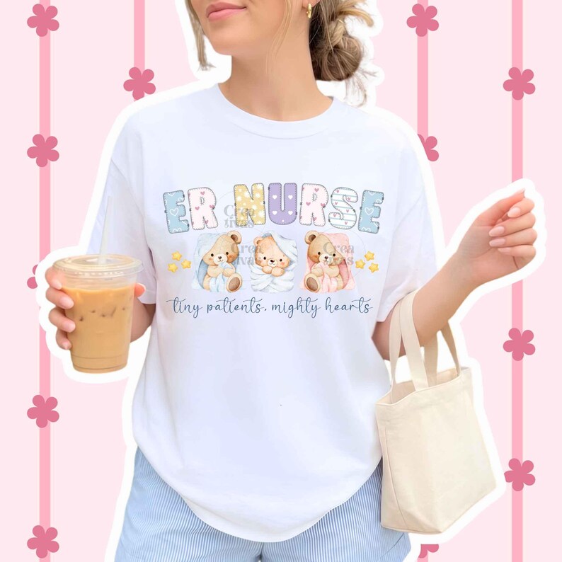 May include: A white short-sleeve t-shirt featuring the text ER NURSE in colorful patterned letters above three illustrations of teddy bears wrapped in blankets. Below the bears, the text reads tiny patients, mighty hearts in blue script.