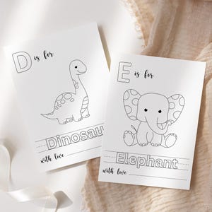 May include: Two white cards with black line drawings of a dinosaur and an elephant. The dinosaur card says "D is for Dinosaur" and the elephant card says "E is for Elephant". Both cards have the words "with love" at the bottom.
