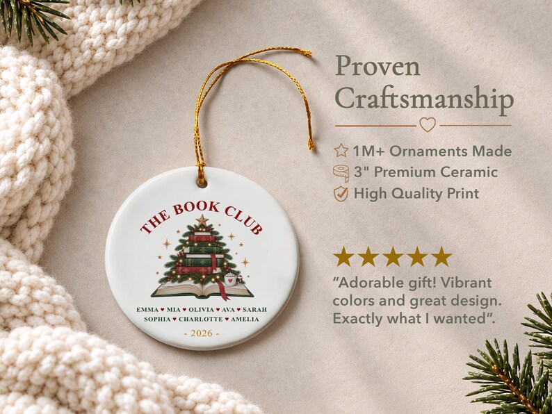 May include: A round white ceramic ornament featuring a gold hanging string. The design includes the text THE BOOK CLUB, a Christmas tree made of stacked books, and a list of names separated by hearts, with the year 2026 printed at the bottom.