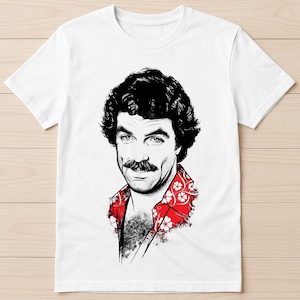 May include: White t-shirt featuring a black and white illustration of a man with a mustache and curly hair. The man is wearing a red floral print shirt. The graphic is a stylized portrait.
