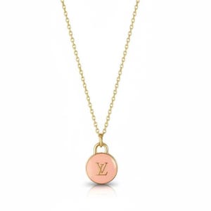 Pode incluir: Um colar dourado com uma corrente delicada. O pingente é um charme redondo rosa claro com a letra "L" e um "V" estilizado dourados no centro. O colar é exibido em um fundo branco.