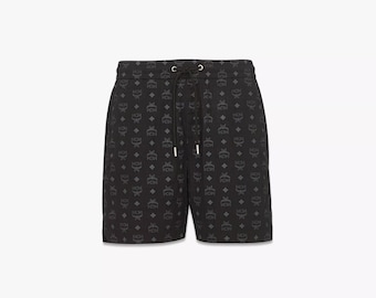Pantalones cortos unisex MCM negros con estampado de monograma, nailon regenerado ECONYL de primera calidad.