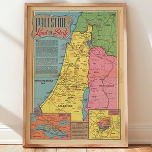 Può includere: Una mappa vintage incorniciata della Palestina, con dettagli geografici e il testo "Palestine Land of Strife". La mappa è in una cornice di legno e presenta colori come giallo, blu, rosa e verde.